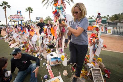 Mynda Smith, sister of Route 91 victim Neysa Tonks, helps move her sister's cross following a c ...