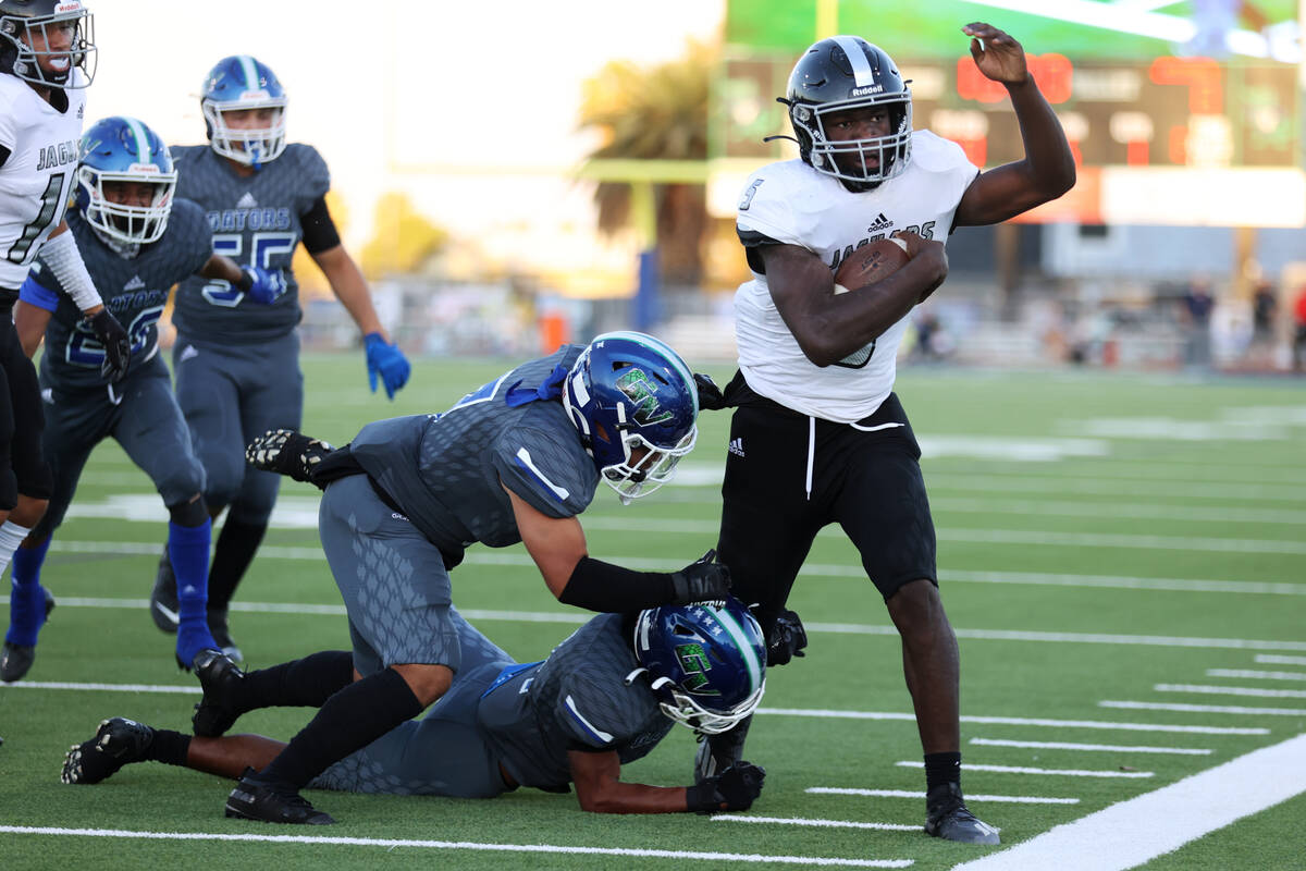 Green Valley's Angel Merino (1) and Chris Aguayo (7) push Desert Pines' Greg Burrell (5) out of ...