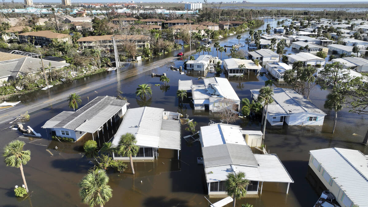 Rescue personnel search a flooded trailer park after Hurricane Ian passed by the area Thursday, ...