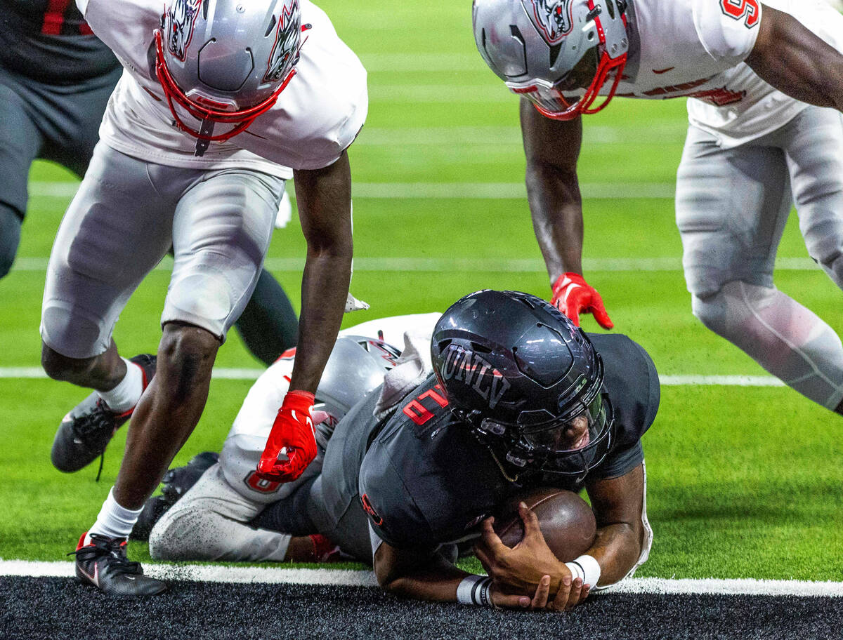 UNLV Rebels quarterback Doug Brumfield (2) dives forward into the end zone over New Mexico Lobo ...