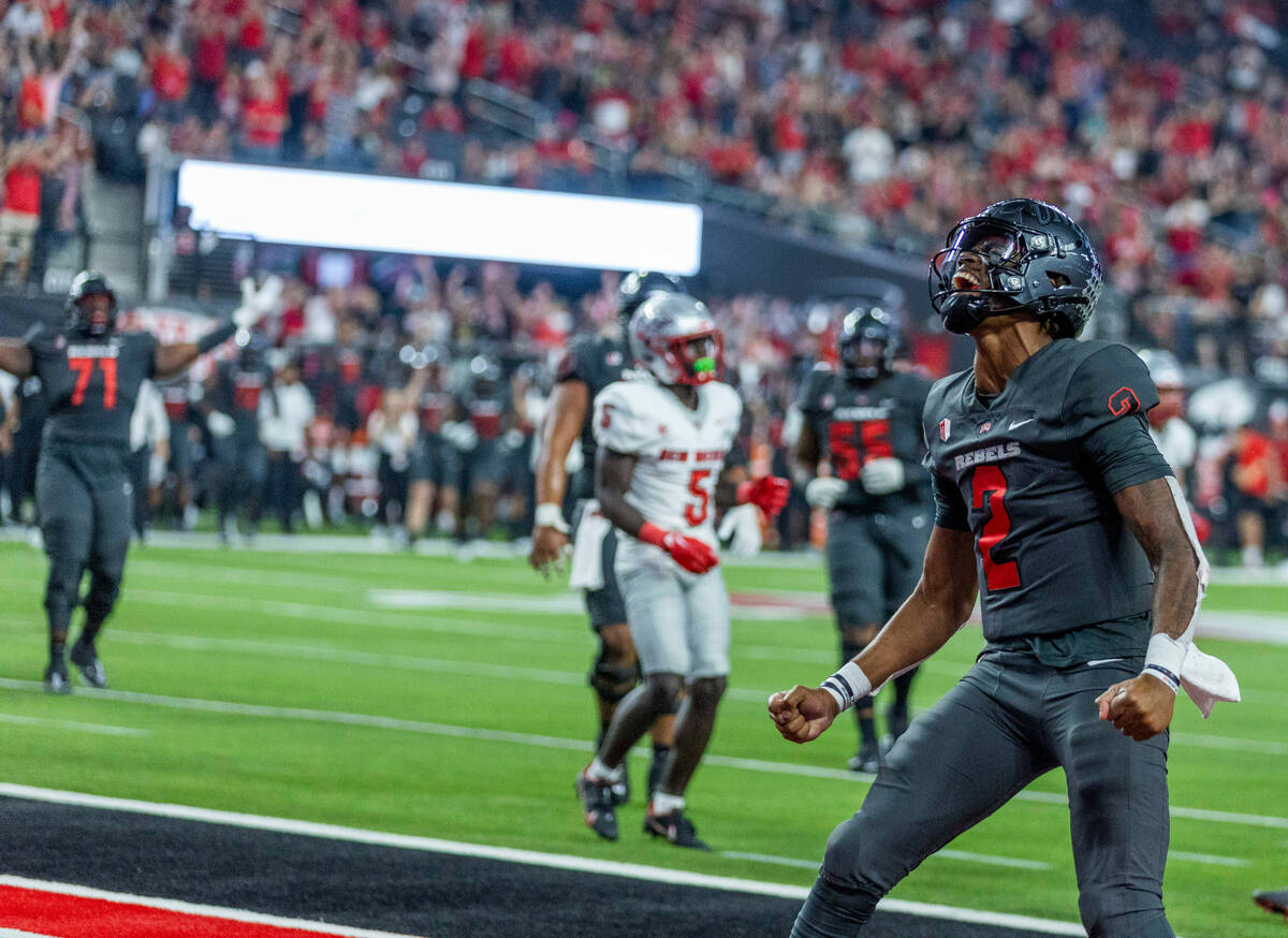 UNLV Rebels quarterback Doug Brumfield (2) celebrates a score over New Mexico Lobos defenders d ...