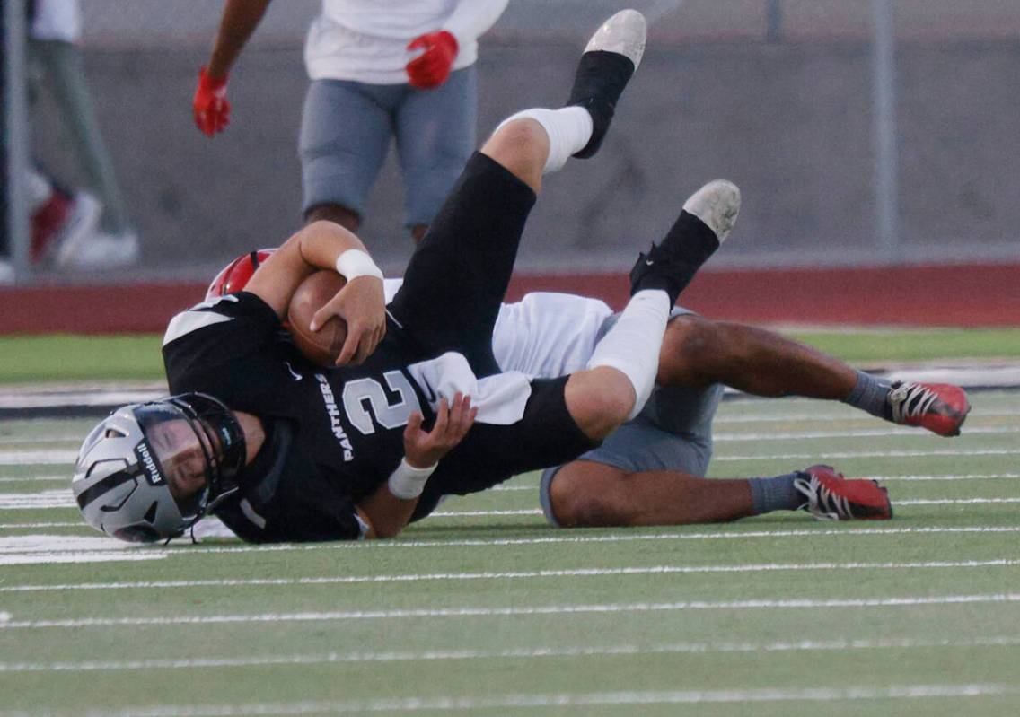 Arbor View’s Talavoutuputoa Howard, behind, sacks Palo Verde’s quarterback Crew D ...