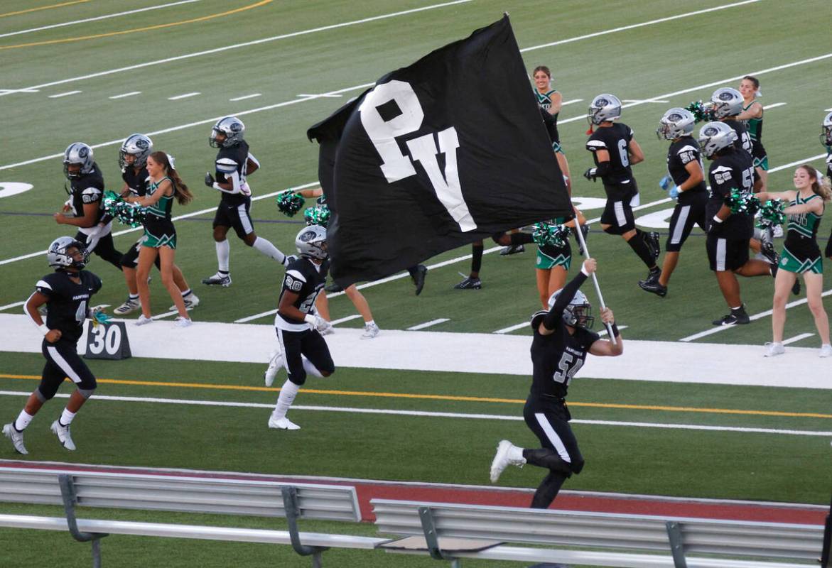 Palo Verde’s Dustin Kane, center, runs out to the field with holding a flag before a foo ...