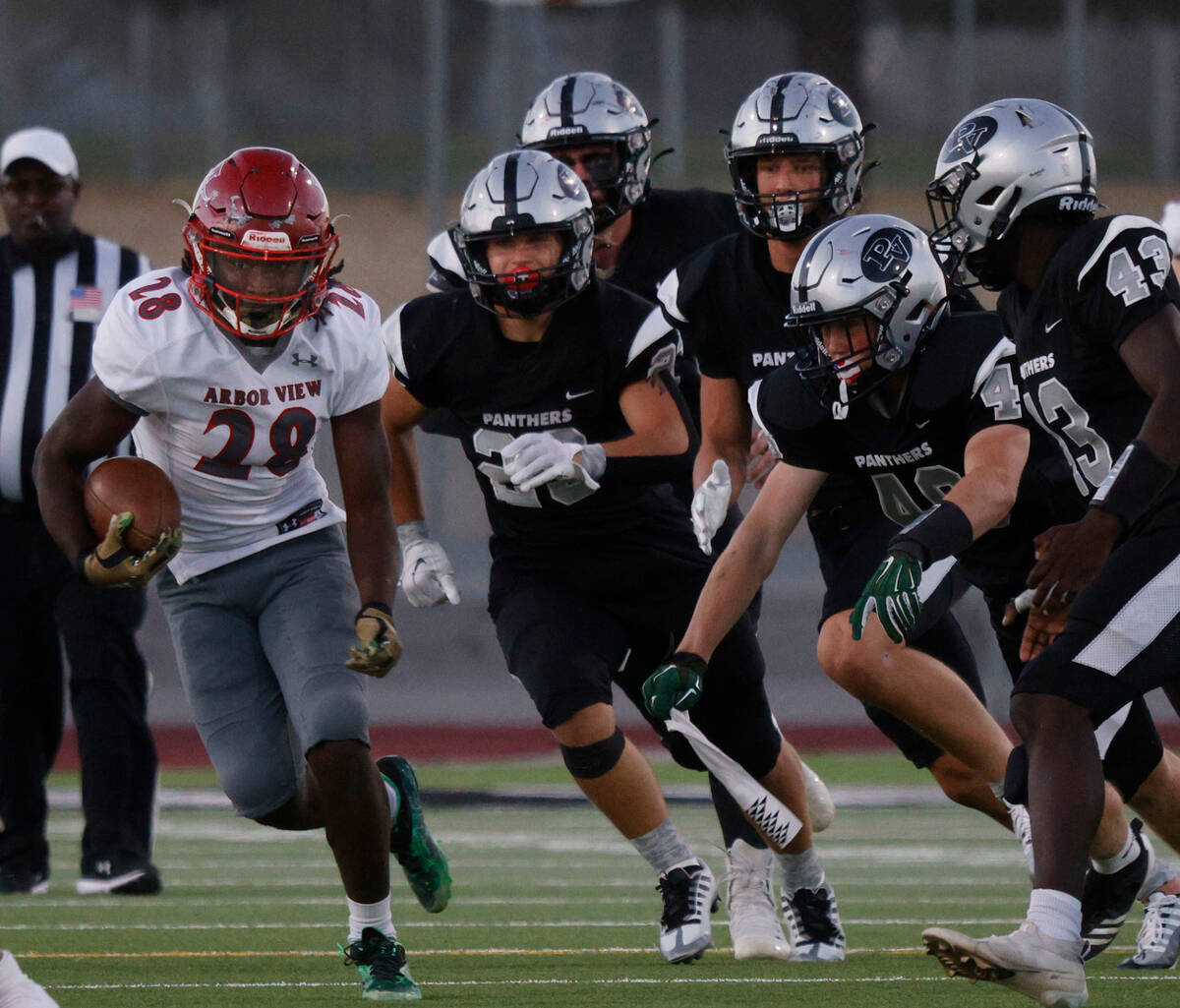 Arbor View’s Nylon Johnson (28) carries the ball as Palo Verde players follow him during ...