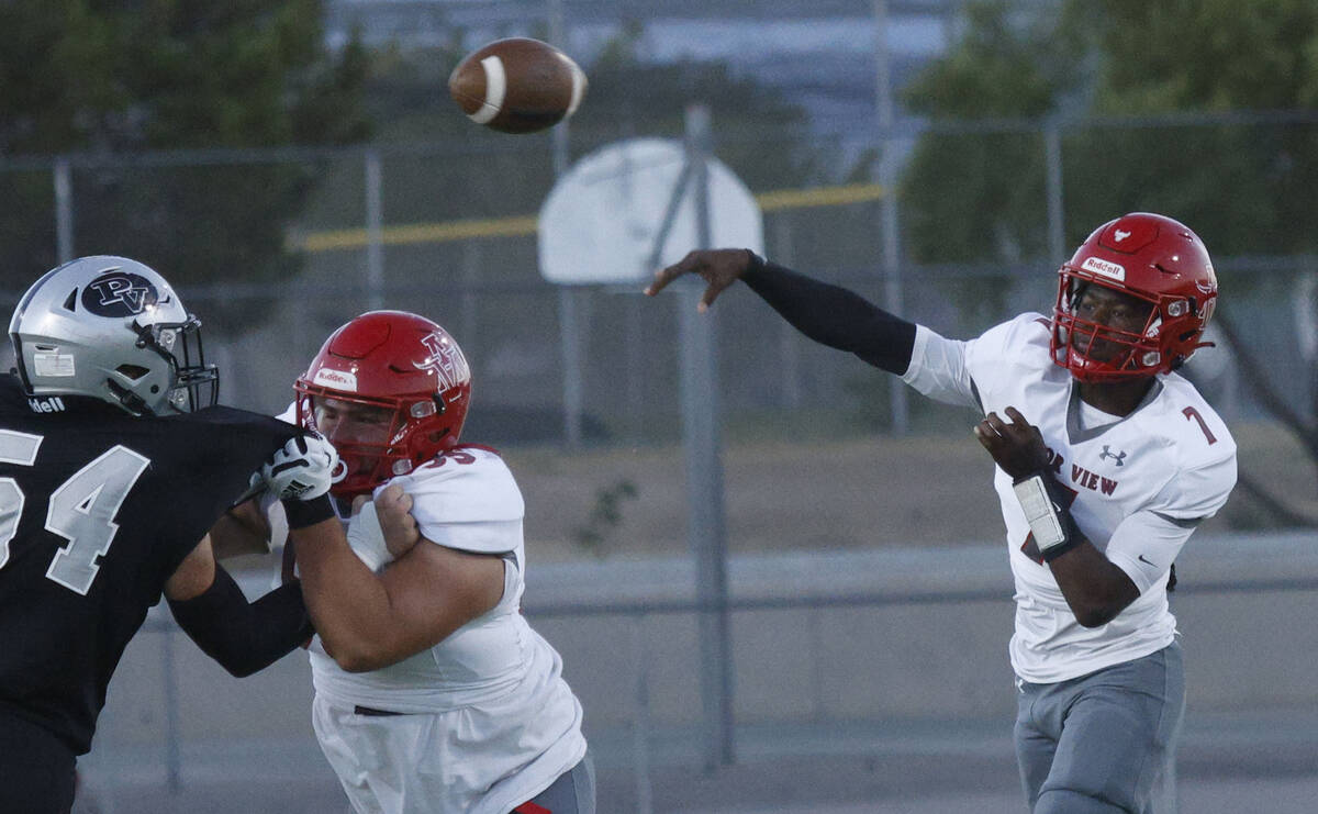 Arbor View’s quarterback Michael Kearns (7) throws a pass as his teammate Damien Beltran ...
