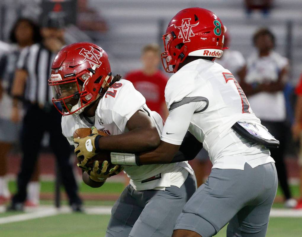 Arbor View’s quarterback Michael Kearns (7) hands off to Nylon Johnson (28) during the f ...