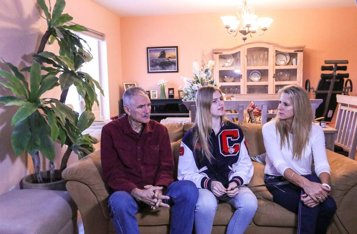 Sasha Bolla, center, responds to a question as she and her parents, former basketball coaches, ...