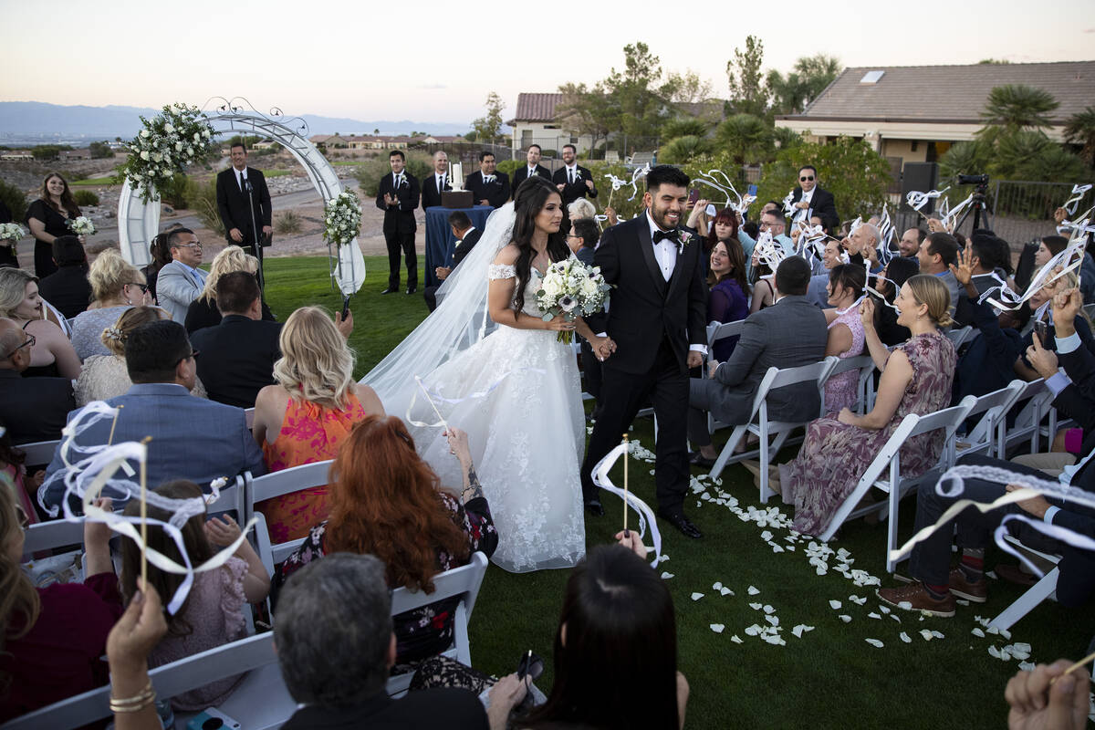 Brittany Castrejon, left, and her husband Jorge Gonzalez-Calvillo, walk following their wedding ...