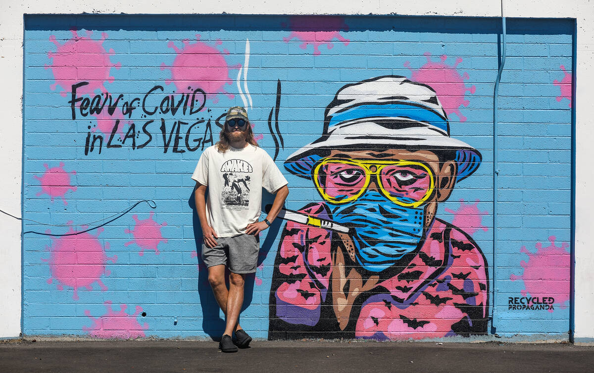Izaac Zevalking, owner and artist at Recycled Propaganda, stands in front of a mural he painted ...