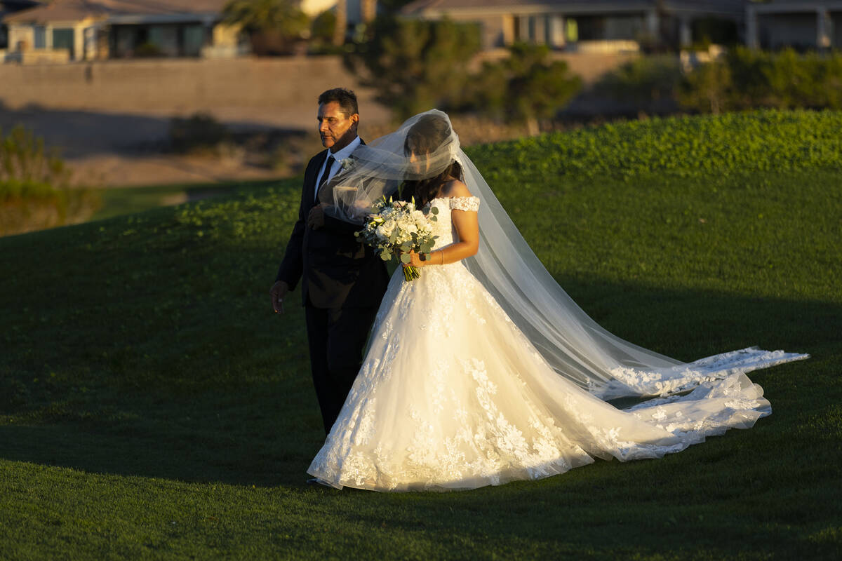 Rogelio Castrejon, left, walks her daughter Brittany Castrejon during her wedding ceremony entr ...