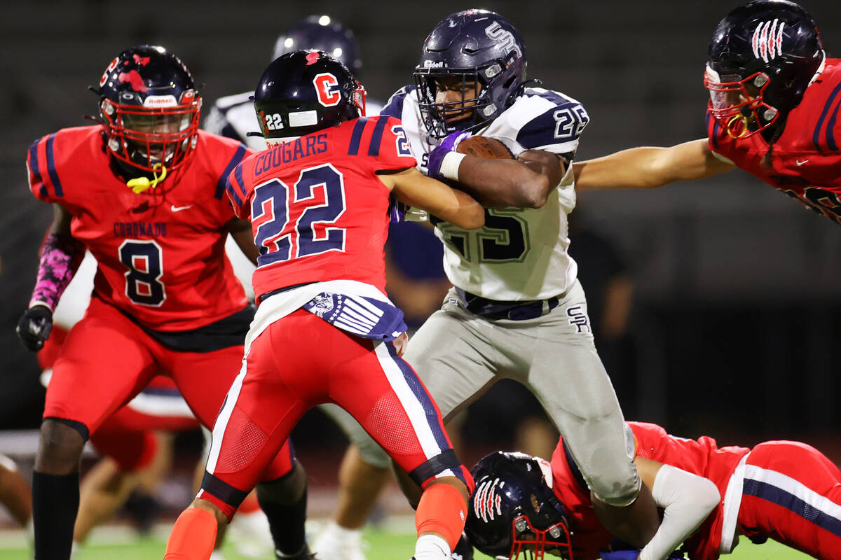 Shadow Ridge's Jaquieze Holland (25) runs the ball before getting tackled by Coronado's Jeremia ...