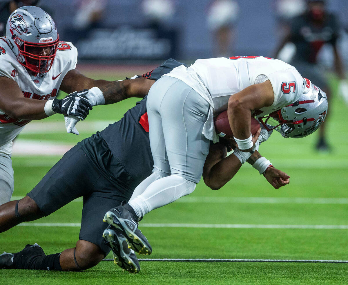 UNLV Rebels defensive lineman Jalen Dixon (50) pulls New Mexico Lobos quarterback Miles Kendric ...