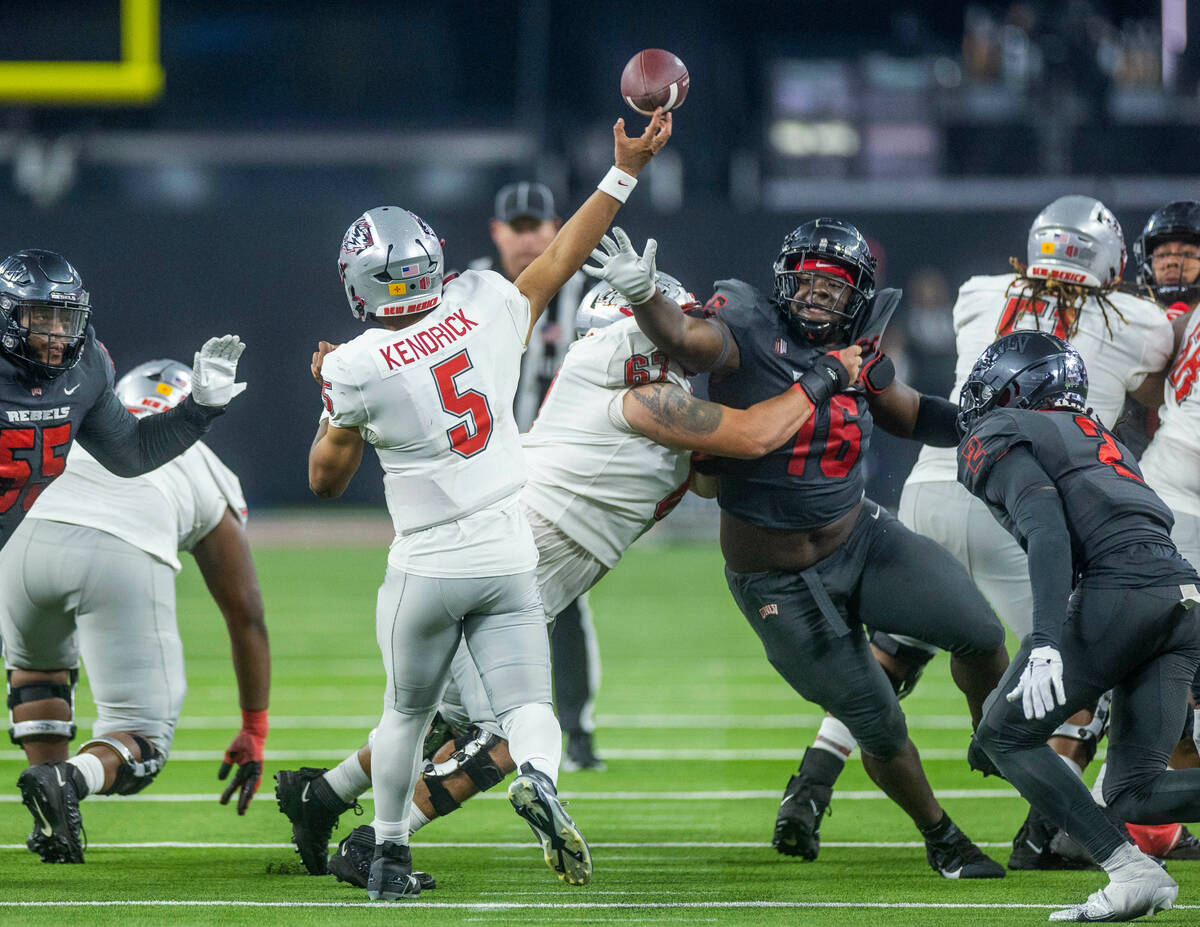 New Mexico Lobos quarterback Miles Kendrick (5) has a pass altered by UNLV Rebels defensive lin ...