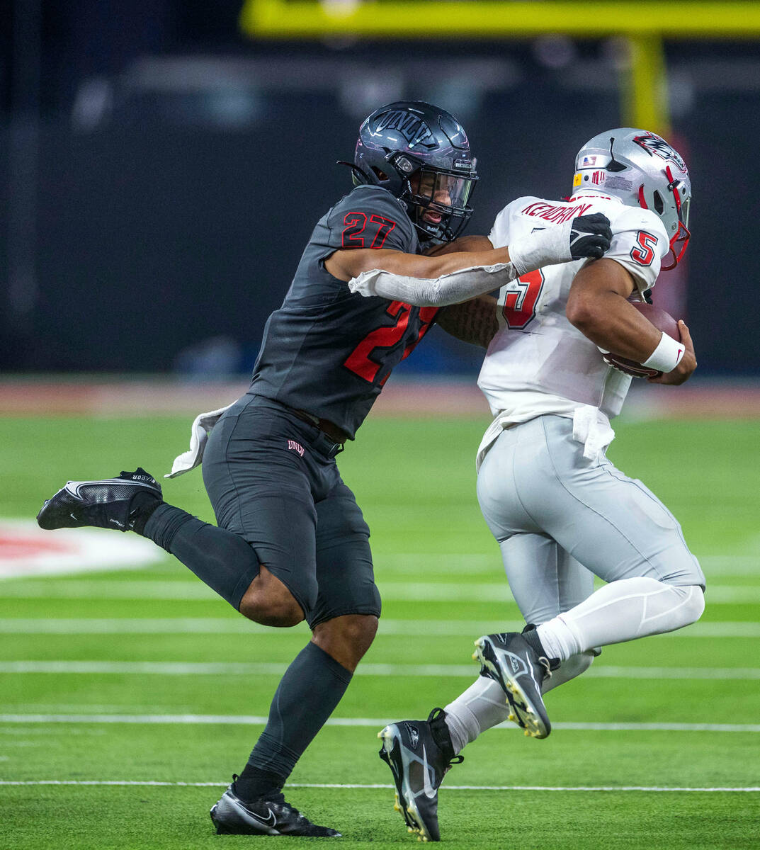 UNLV Rebels linebacker Austin Ajiake (27) sacks New Mexico Lobos quarterback Miles Kendrick (5) ...