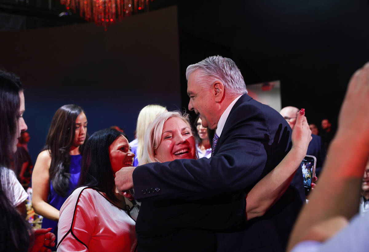 Gov. Steve Sisolak embraces Jenn Closi, whose husband, Metropolitan Police Officer Phil Closi d ...