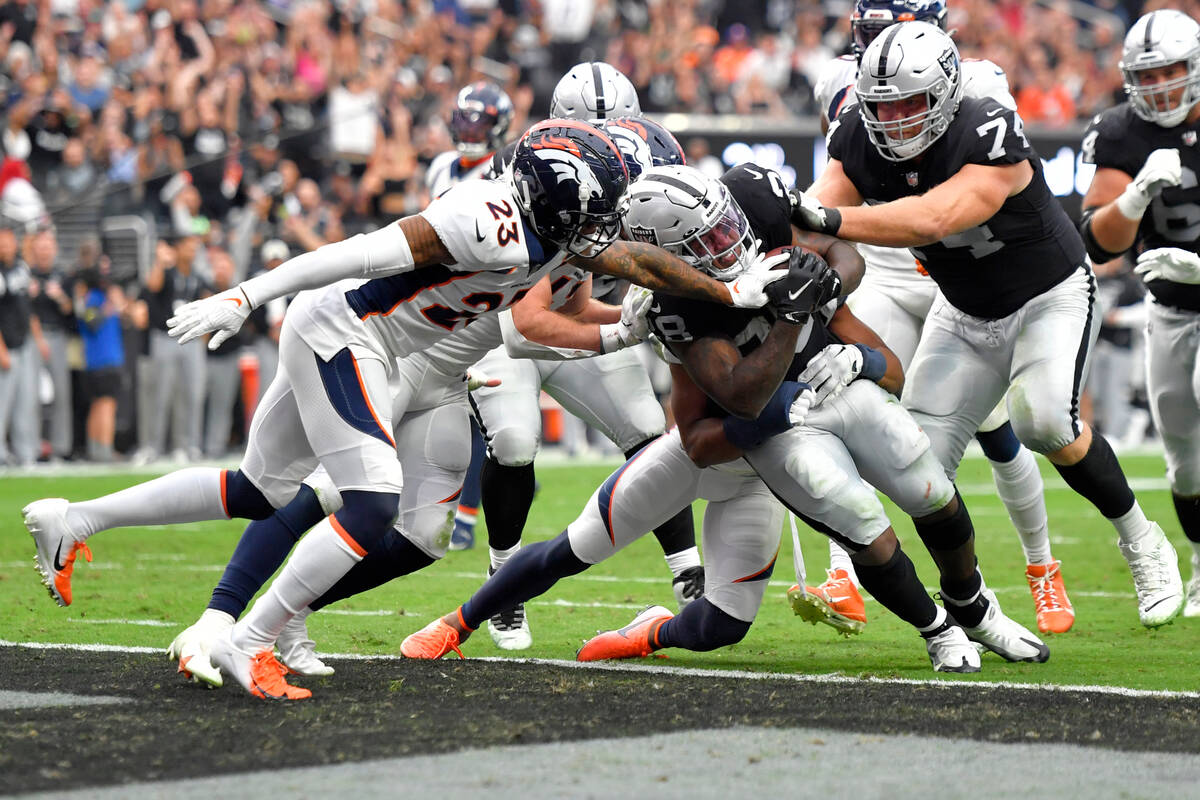 Las Vegas Raiders running back Josh Jacobs (28) scores a touchdown as Denver Broncos linebacker ...
