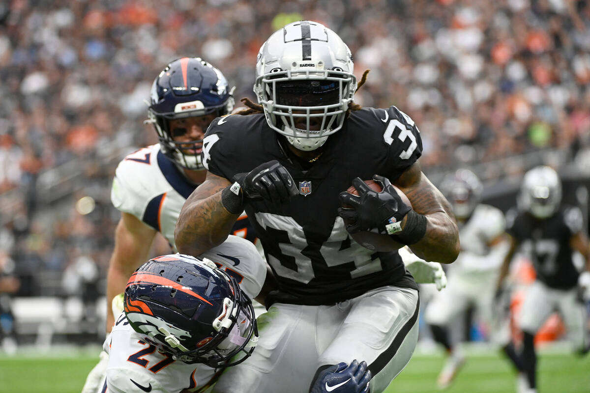 Las Vegas Raiders running back Brandon Bolden (34) pulls in a pass as Denver Broncos cornerback ...