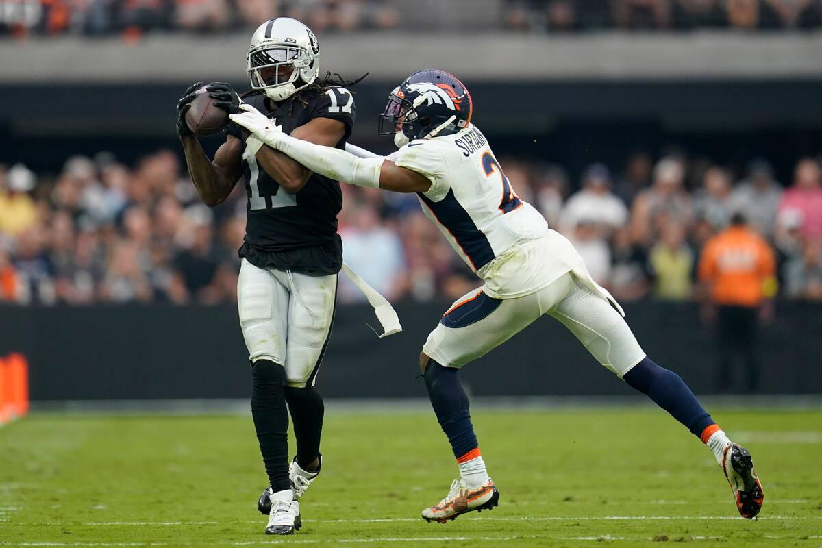 Las Vegas Raiders wide receiver Davante Adams (17) makes a catch as Denver Broncos cornerback P ...