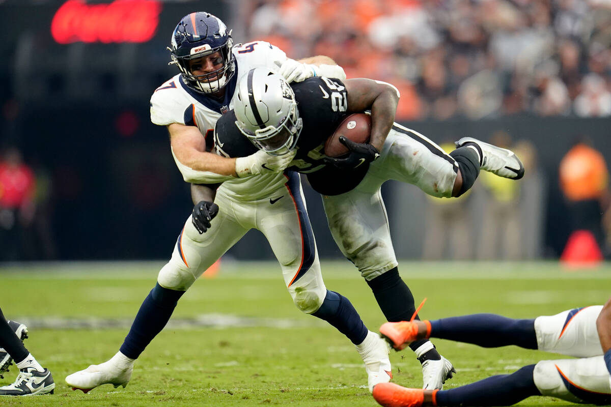 Las Vegas Raiders running back Josh Jacobs (28) is tackled by Denver Broncos linebacker Josey J ...