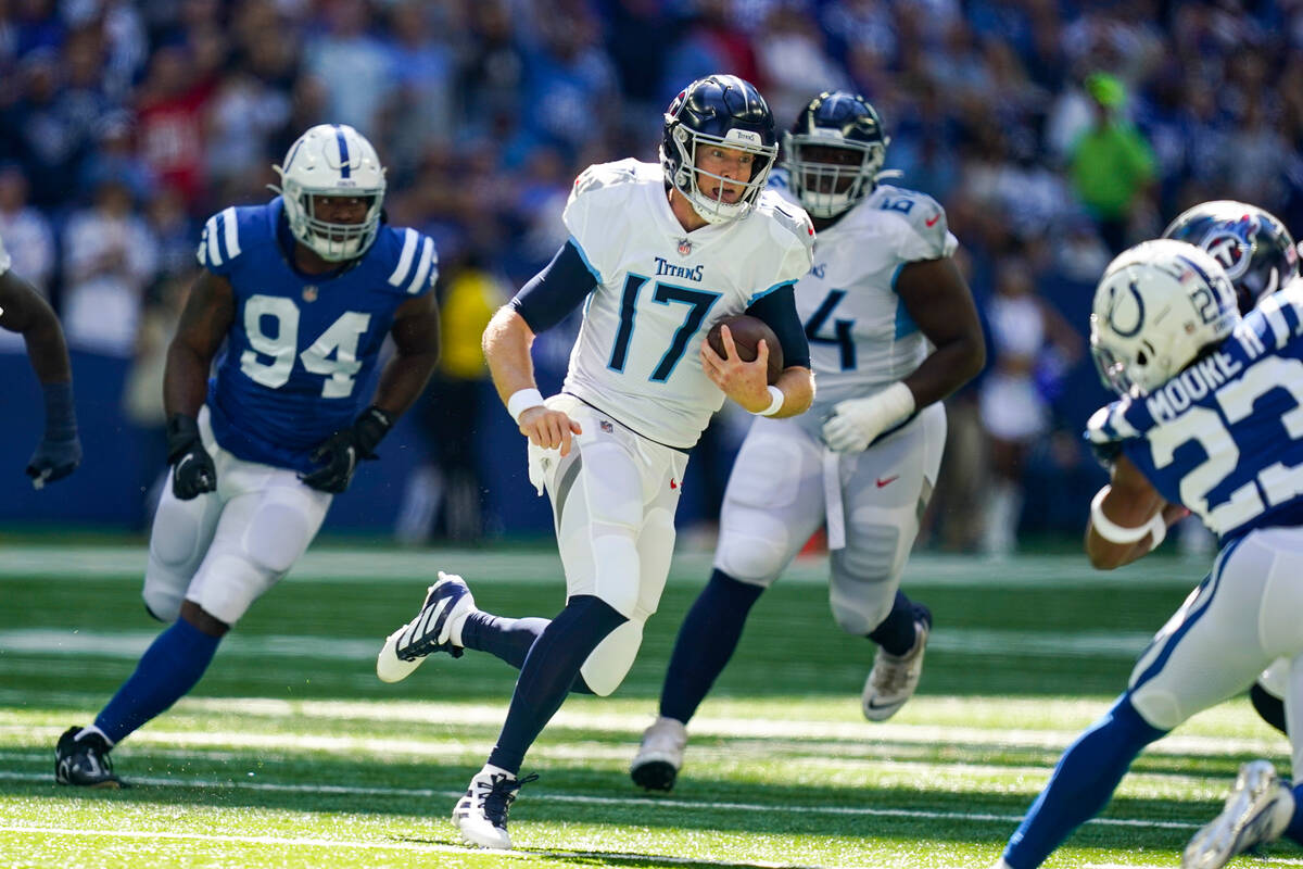 Tennessee Titans quarterback Ryan Tannehill scramble away from Indianapolis Colts defensive end ...