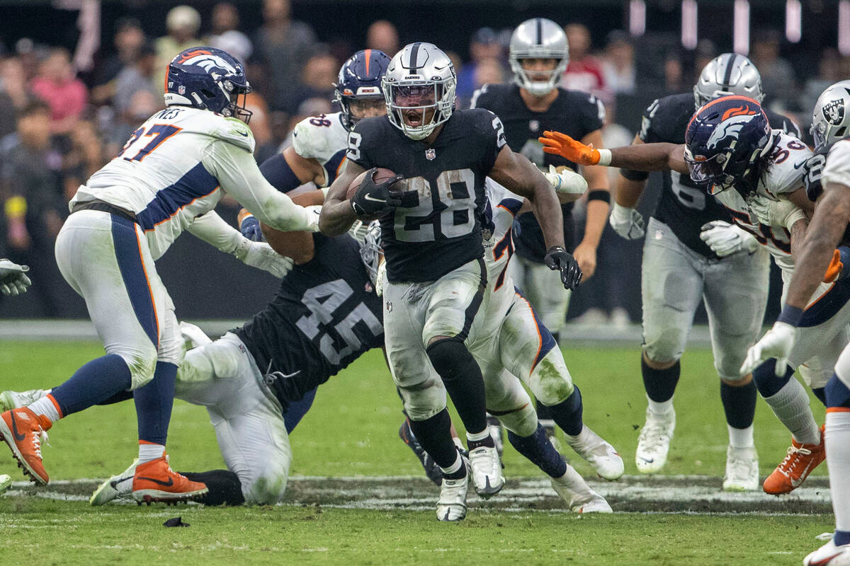 Raiders running back Josh Jacobs (28) runs into Denver Broncos territory during the second half ...
