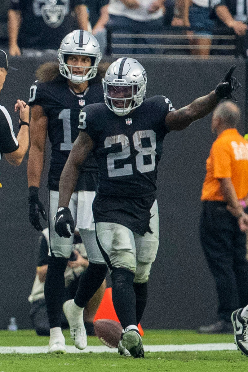 Raiders running back Josh Jacobs (28) signals the for a first down with Raiders wide receiver M ...