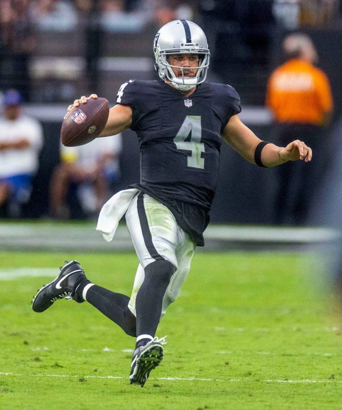 Raiders quarterback Derek Carr (4) scoots down the sidelines on a run versus the Denver Broncos ...