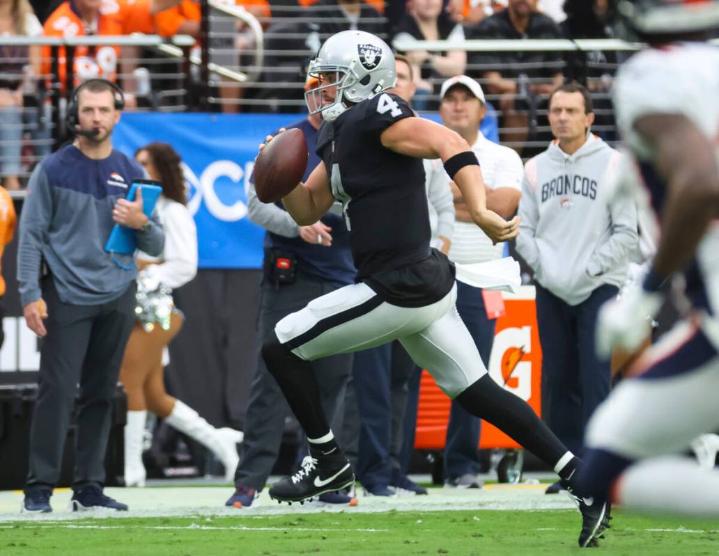 Raiders quarterback Derek Carr (4) runs the ball against the Denver Broncos during the first ha ...