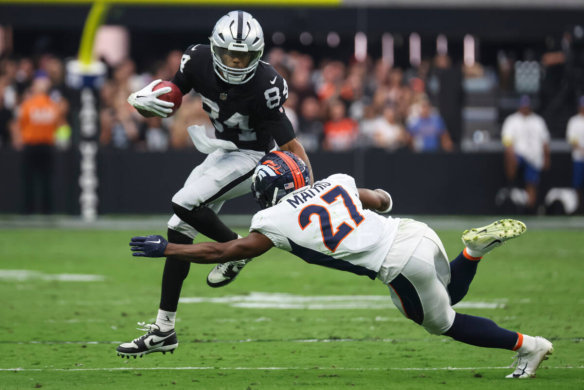 Raiders wide receiver Keelan Cole (84) gets tackled by Denver Broncos cornerback Damarri Mathis ...