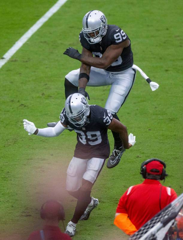 Raiders cornerback Nate Hobbs (39) and defensive end Clelin Ferrell (99) celebrate a Denver Bro ...