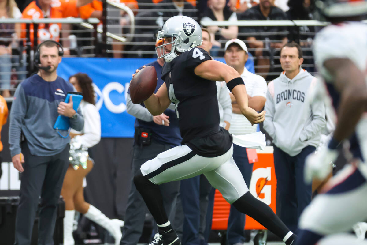 Raiders quarterback Derek Carr (4) runs the ball against the Denver Broncos during the first ha ...