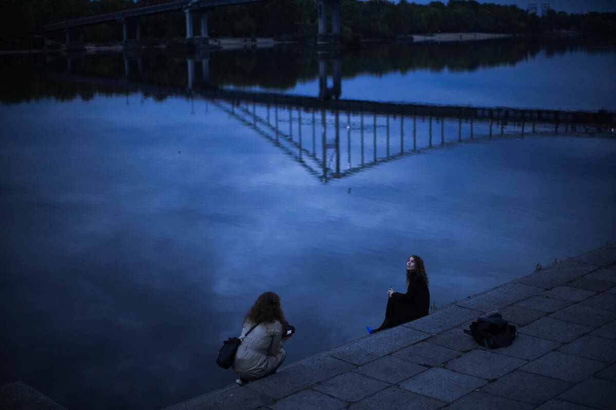 A woman poses for a photo session at the Dnipro riverbank in Kyiv, Ukraine, Saturday, Oct. 1, 2 ...