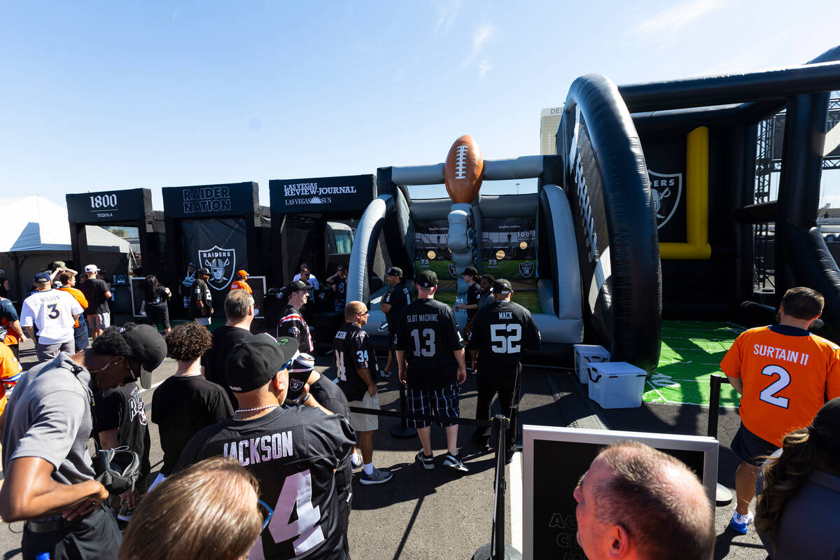Football fans explore the Modelo tailgate zone before the start of an NFL game between the Raid ...