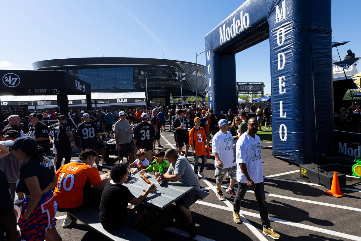 Football fans explore the Modelo tailgate zone before the start of an NFL game between the Raid ...
