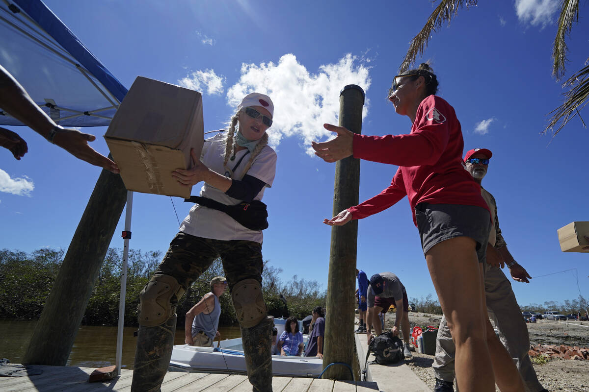 Volunteers form a human chain to offload emergency supplies that arrived by boat in the afterma ...