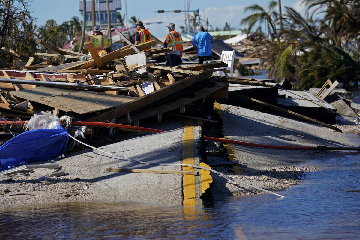 Responders from the de Moya Group survey damage to the bridge leading to Pine Island, to start ...