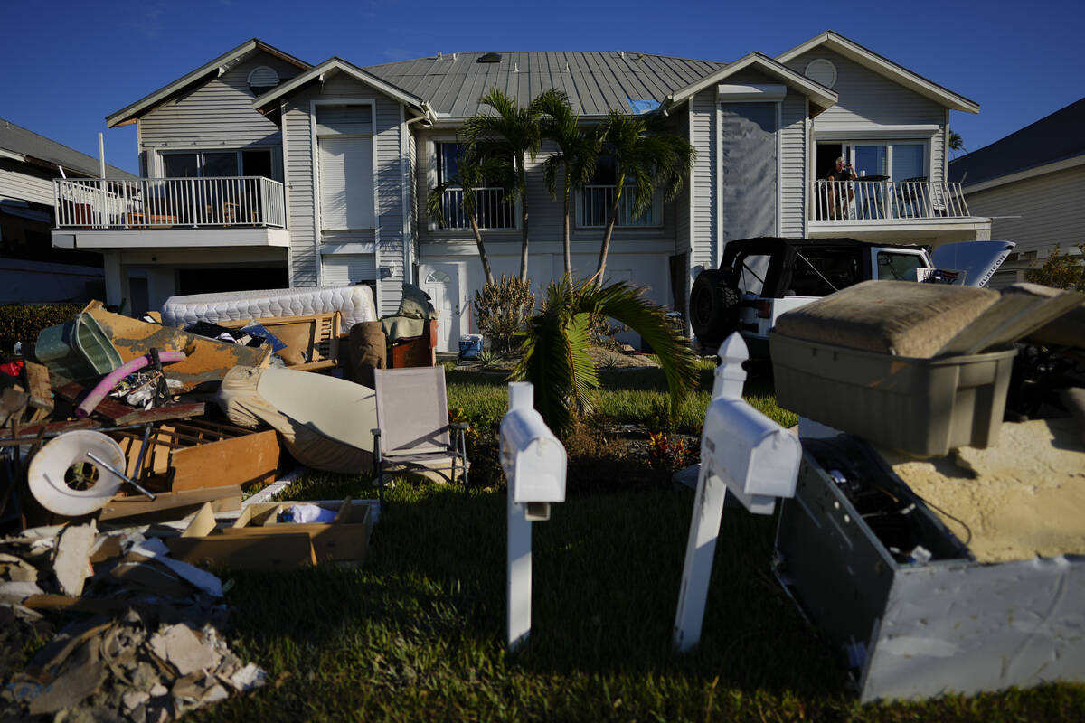 Darryl Hudson of Ontario, Canada, has a morning coffee on the damaged balcony of his vacation h ...