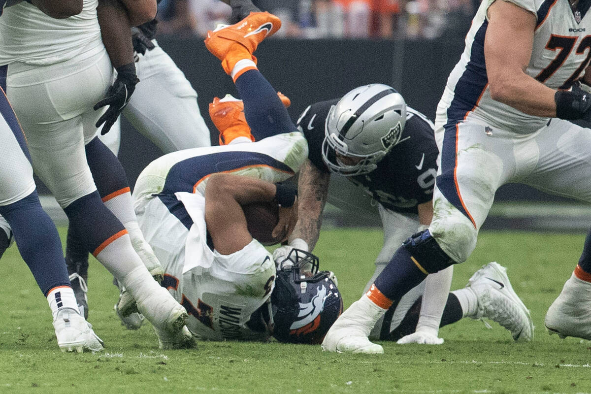 Raiders defensive end Maxx Crosby (98) sacks Denver Broncos quarterback Russell Wilson (3) duri ...