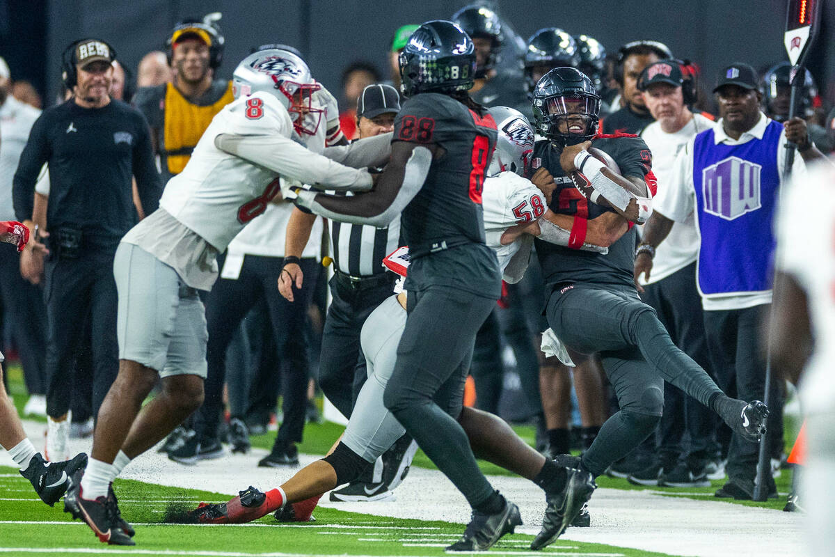 UNLV Rebels quarterback Doug Brumfield (2) is hit late on the sidelines by New Mexico Lobos lin ...