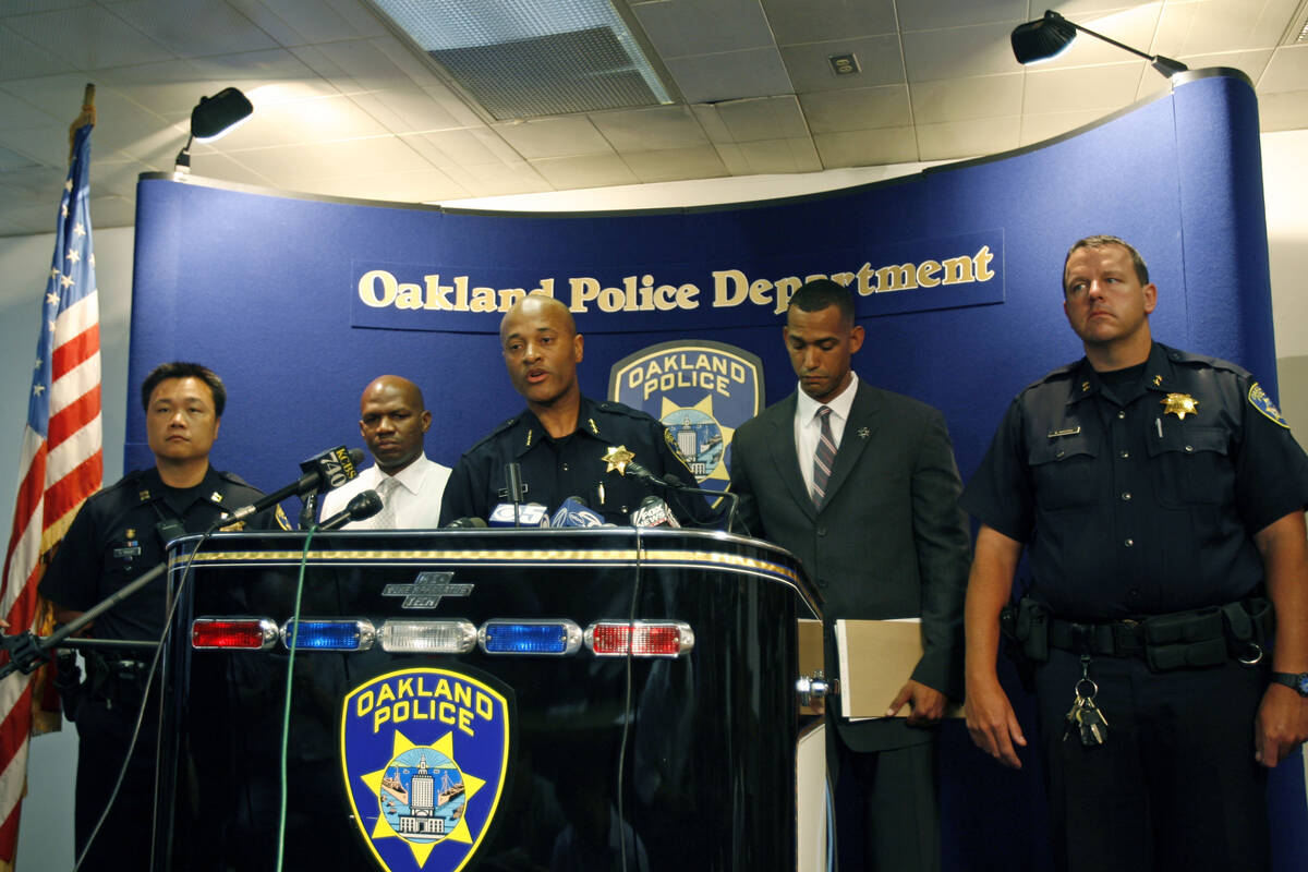 Oakland Assistant Police Chief Howard Jordan, center, takes questions from the media during a n ...