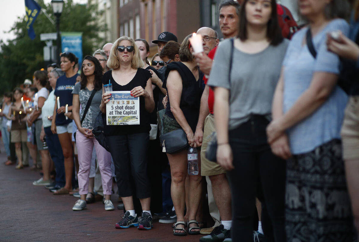 People stand in silence during a vigil in response to a shooting in the Capital Gazette newsroo ...