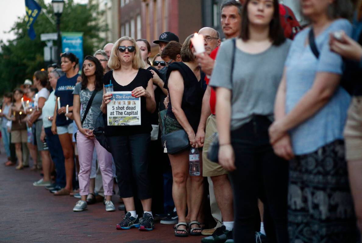 People stand in silence during a vigil in response to a shooting in the Capital Gazette newsroo ...