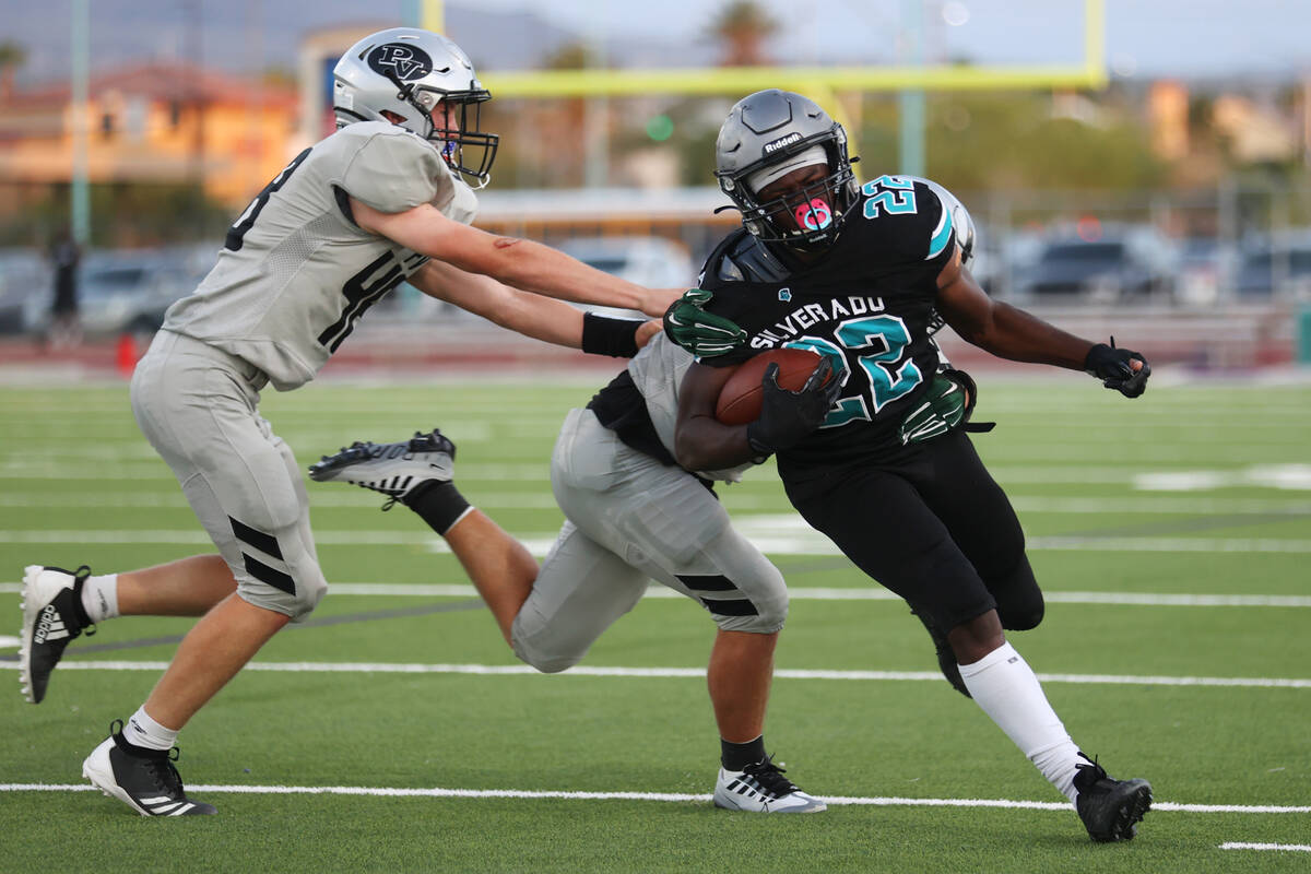 Silverado's Caden Harris (22) runs the ball against Palo Verde's Blair Thayer (23) and Koda Bro ...