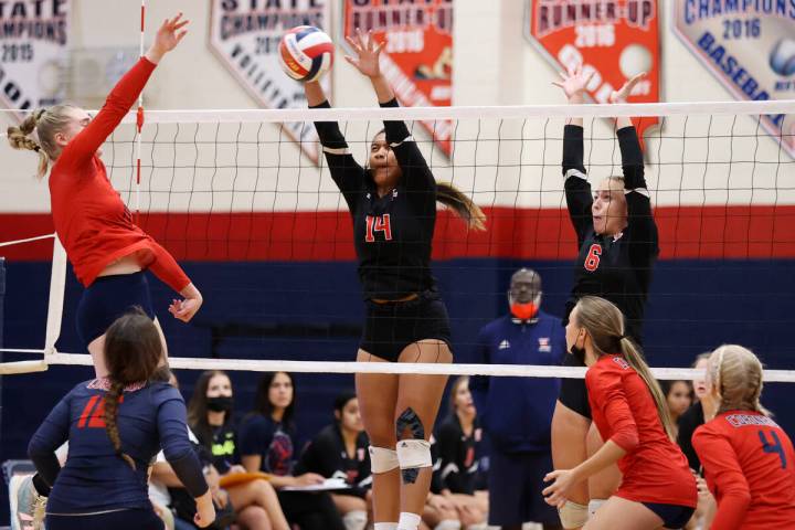 Coronado's Angelina Sayles (17) spikes the ball as Liberty's Romona Pulu (14) and Jaylynn McCar ...