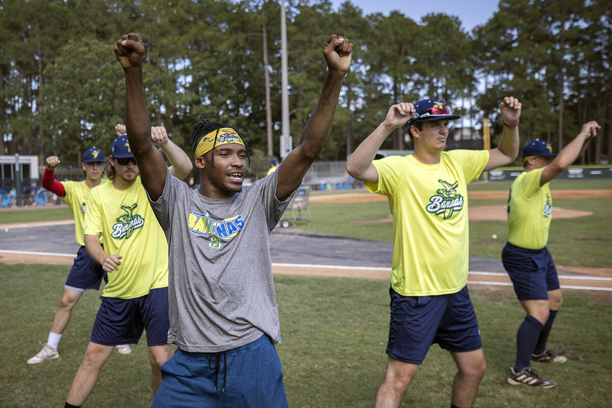 FILE - Savannah Bananas first base coach Maceo Harrison, foreground, teaches a dance routine to ...