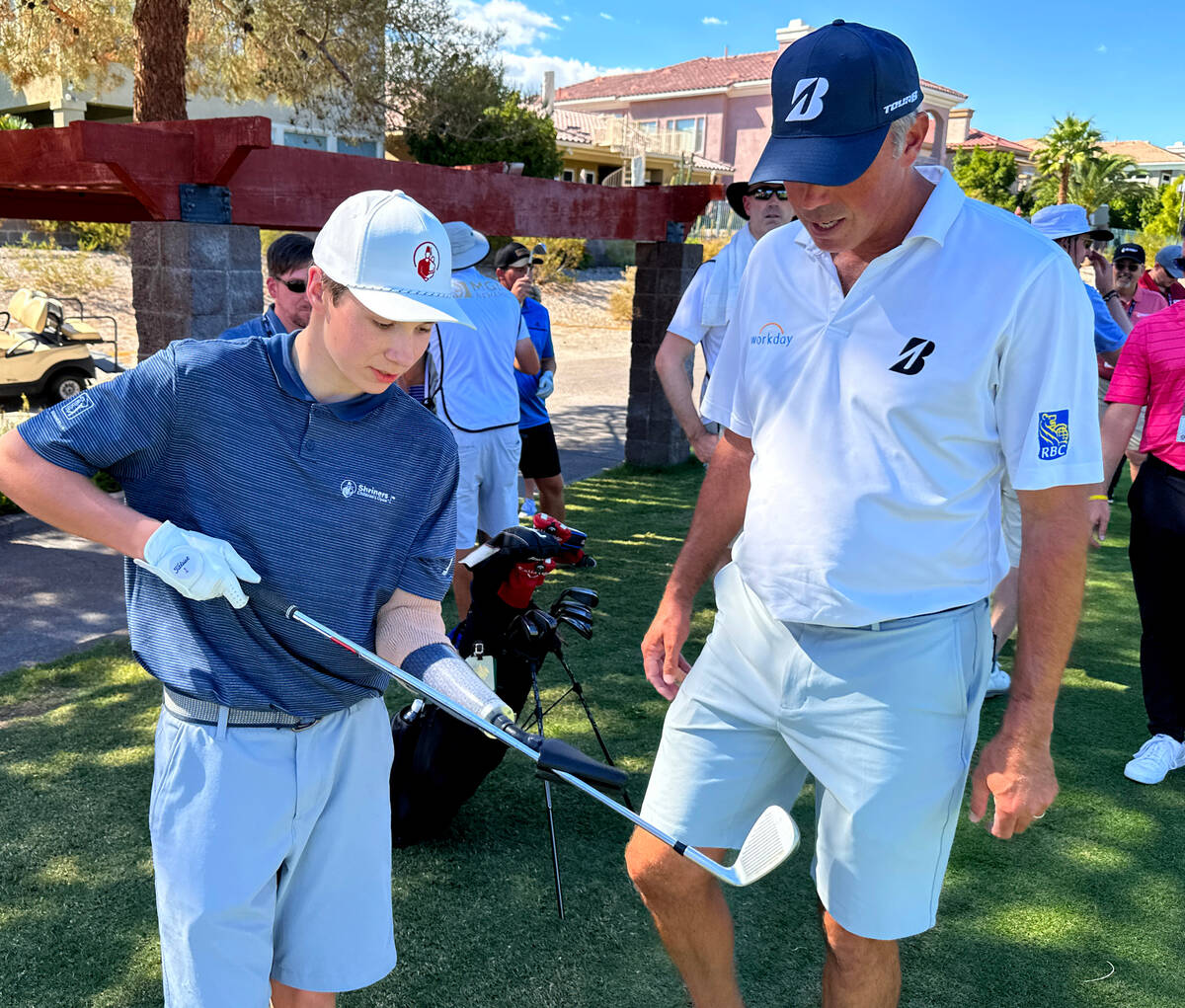 Shriners patient ambassador Isaac Berger, 17, of Neillsville, Wis. shows PGA Tour player Matt K ...