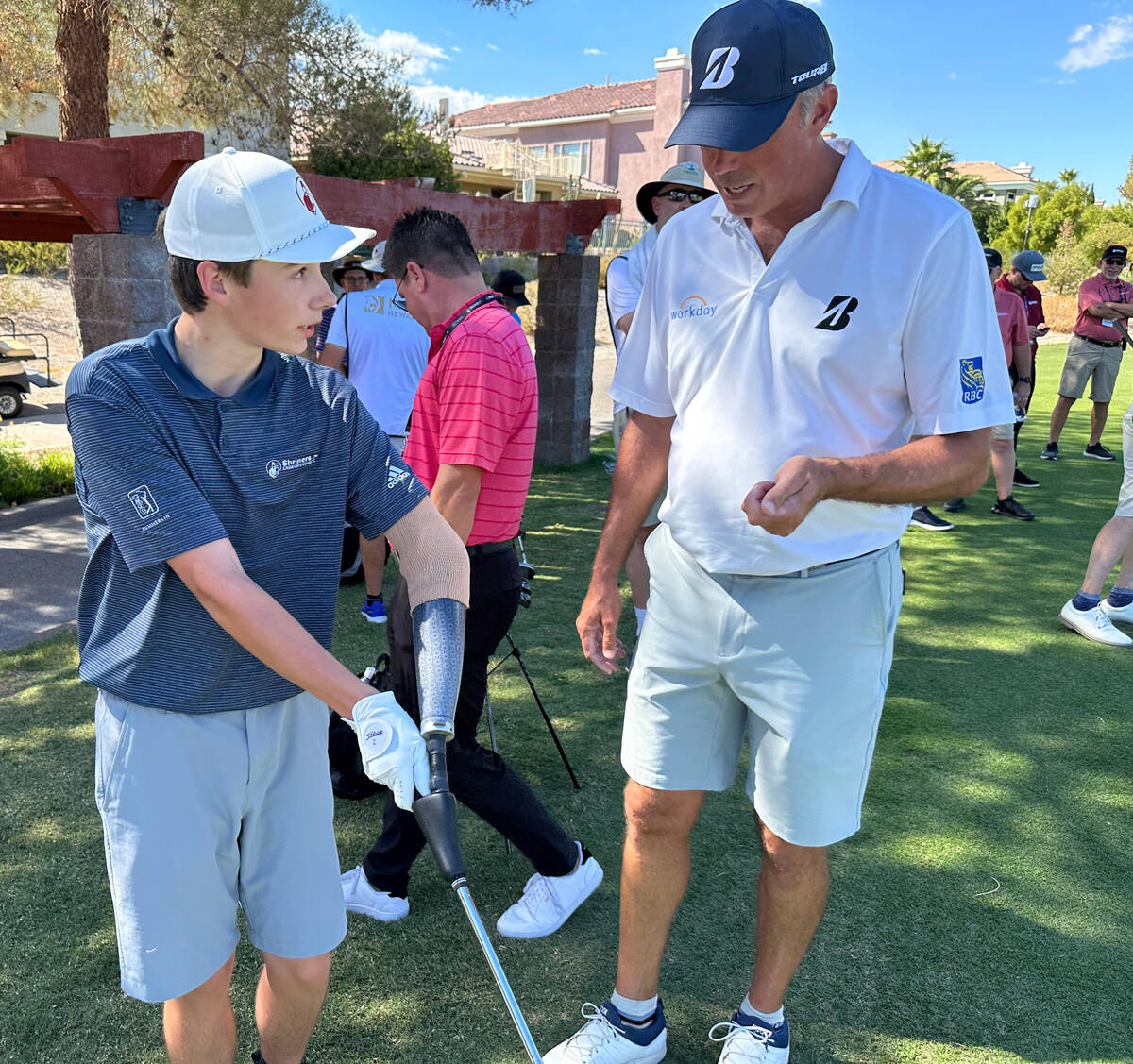 Shriners patient ambassador Isaac Berger, 17, of Neillsville, Wis. shows PGA Tour player Matt K ...