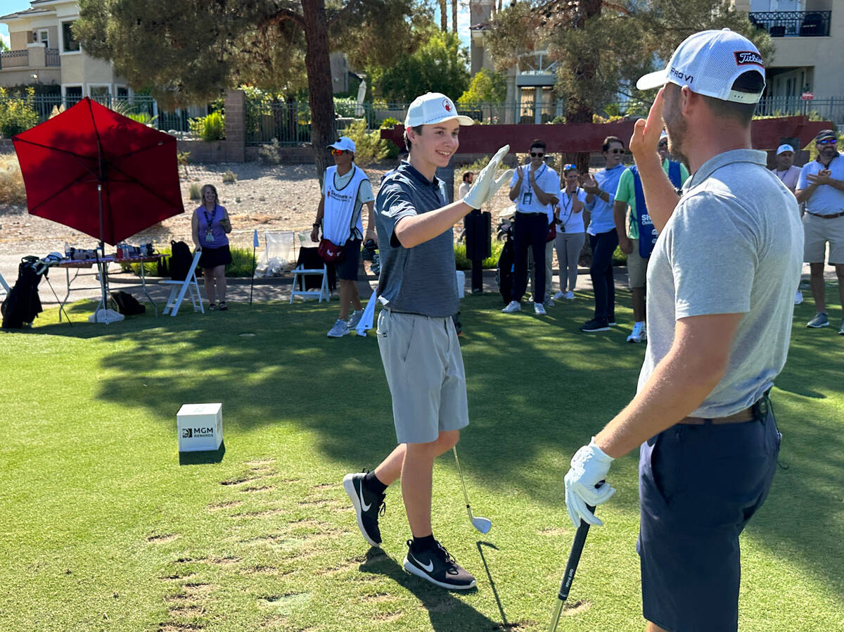 Shriners patient ambassador Isaac Berger, 17, of Neillsville, Wis. celebrates his shot with PGA ...
