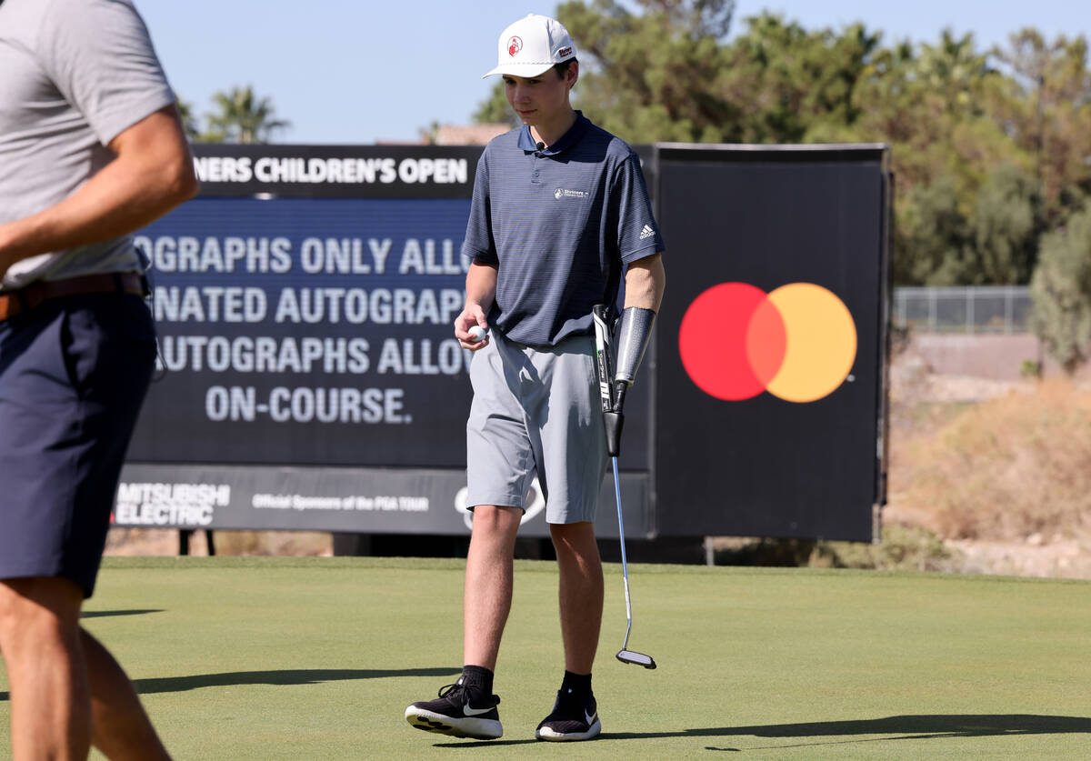 Shriners patient ambassador Isaac Berger, 17, of Neillsville, Wis., lines up his putt on the 14 ...