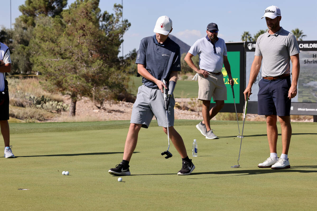 Shriners patient ambassador Isaac Berger, 17, of Neillsville, Wis., left, lines up his putt as ...
